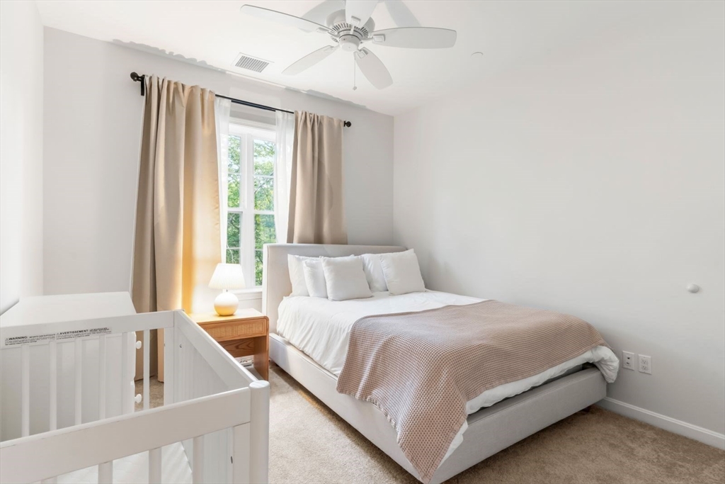 60 Coppersmith Way, Unit 304 Canton, MA 02021 - Photo 17 of 42 a bedroom with a bed and a chandelier