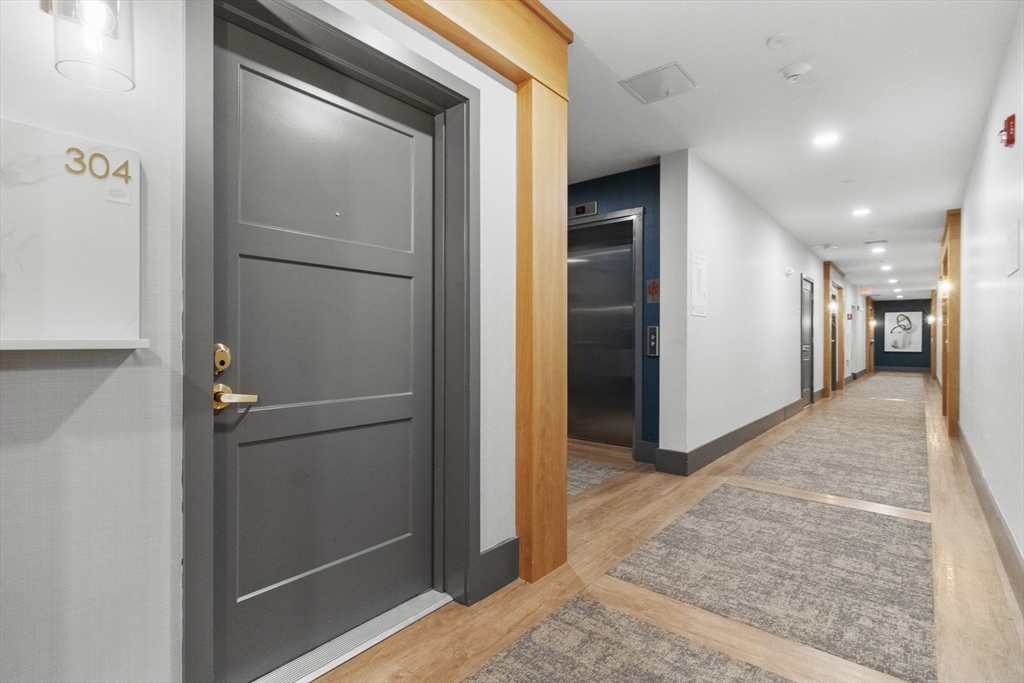 60 Coppersmith Way, Unit 304 Canton, MA 02021 - Photo 24 of 42 a view of a hallway with wooden floor