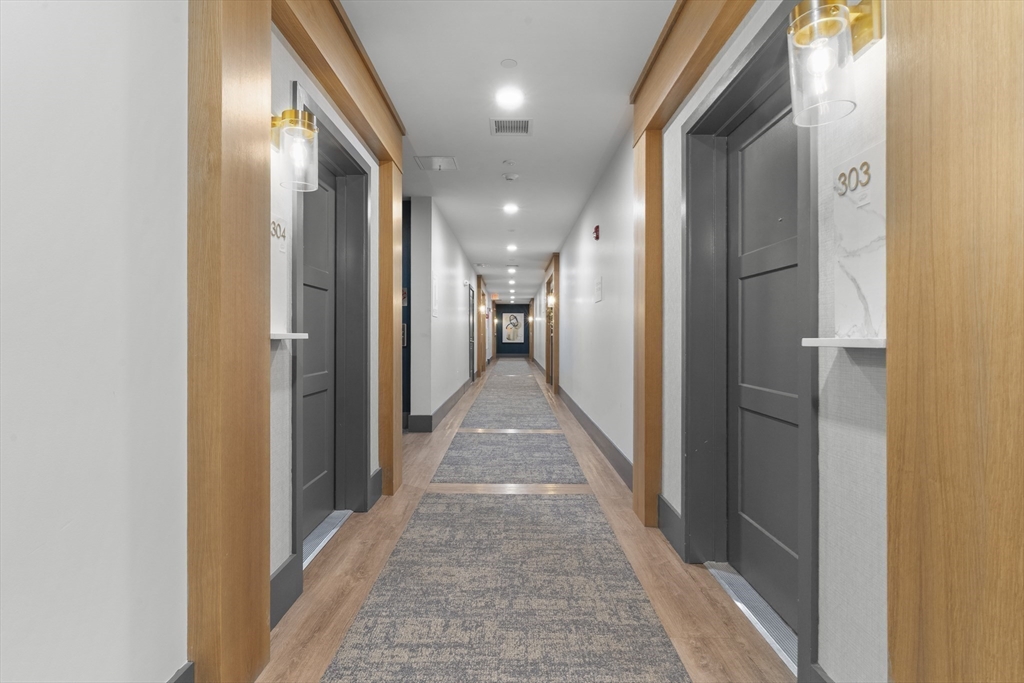 60 Coppersmith Way, Unit 304 Canton, MA 02021 - Photo 25 of 42 a view of a hallway with wooden shelves
