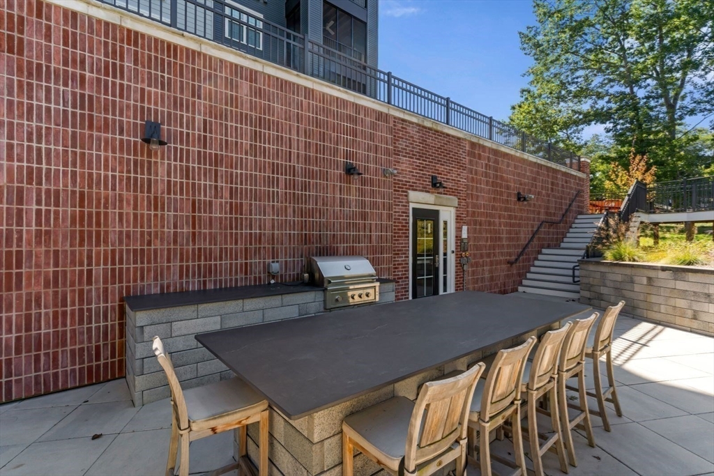 60 Coppersmith Way, Unit 304 Canton, MA 02021 - Photo 30 of 42 a backyard of a house with table and chairs