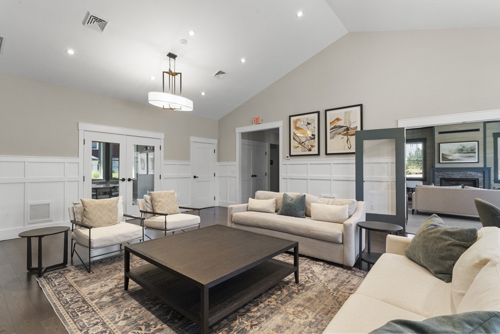60 Coppersmith Way, Unit 304 Canton, MA 02021 - Photo 36 of 42 a living room with furniture a rug and a chandelier
