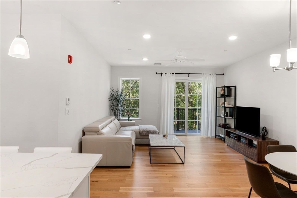 60 Coppersmith Way, Unit 304 Canton, MA 02021 - Photo 5 of 42 a living room with furniture a flat screen tv and a large window