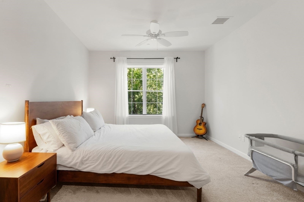 60 Coppersmith Way, Unit 304 Canton, MA 02021 - Photo 9 of 42 a bedroom with a bed and a large window
