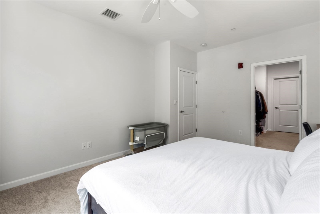 60 Coppersmith Way, Unit 304 Canton, MA 02021 - Photo 10 of 42 a bedroom with a bed and a mirror