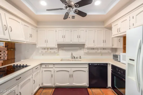 a kitchen with stainless steel appliances granite countertop a sink a stove a refrigerator and cabinets