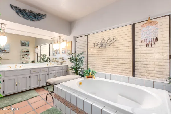 a spacious bathroom with a granite countertop sink a bathtub and next to a window