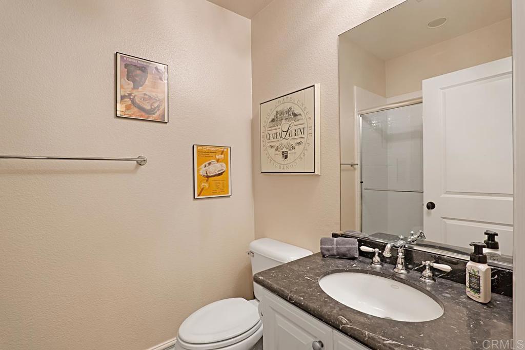 7657 Sitio Algodon Carlsbad, CA 92009 - Photo 20 of 40 a bathroom with a granite countertop sink mirror vanity and toilet