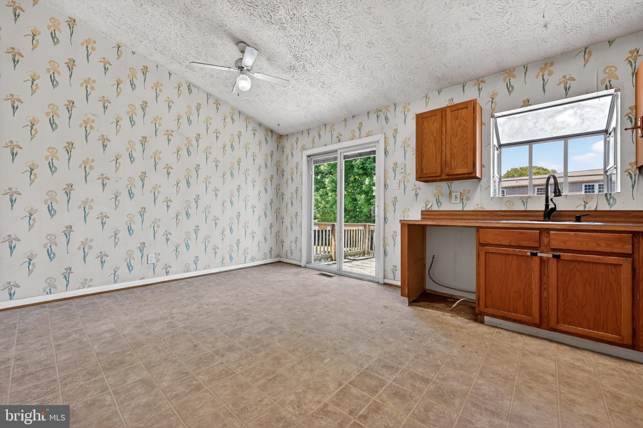 7838 Tick Neck Road Pasadena, MD 21122 - Photo 11 of 20 a view of a kitchen with a sink a fireplace and a window