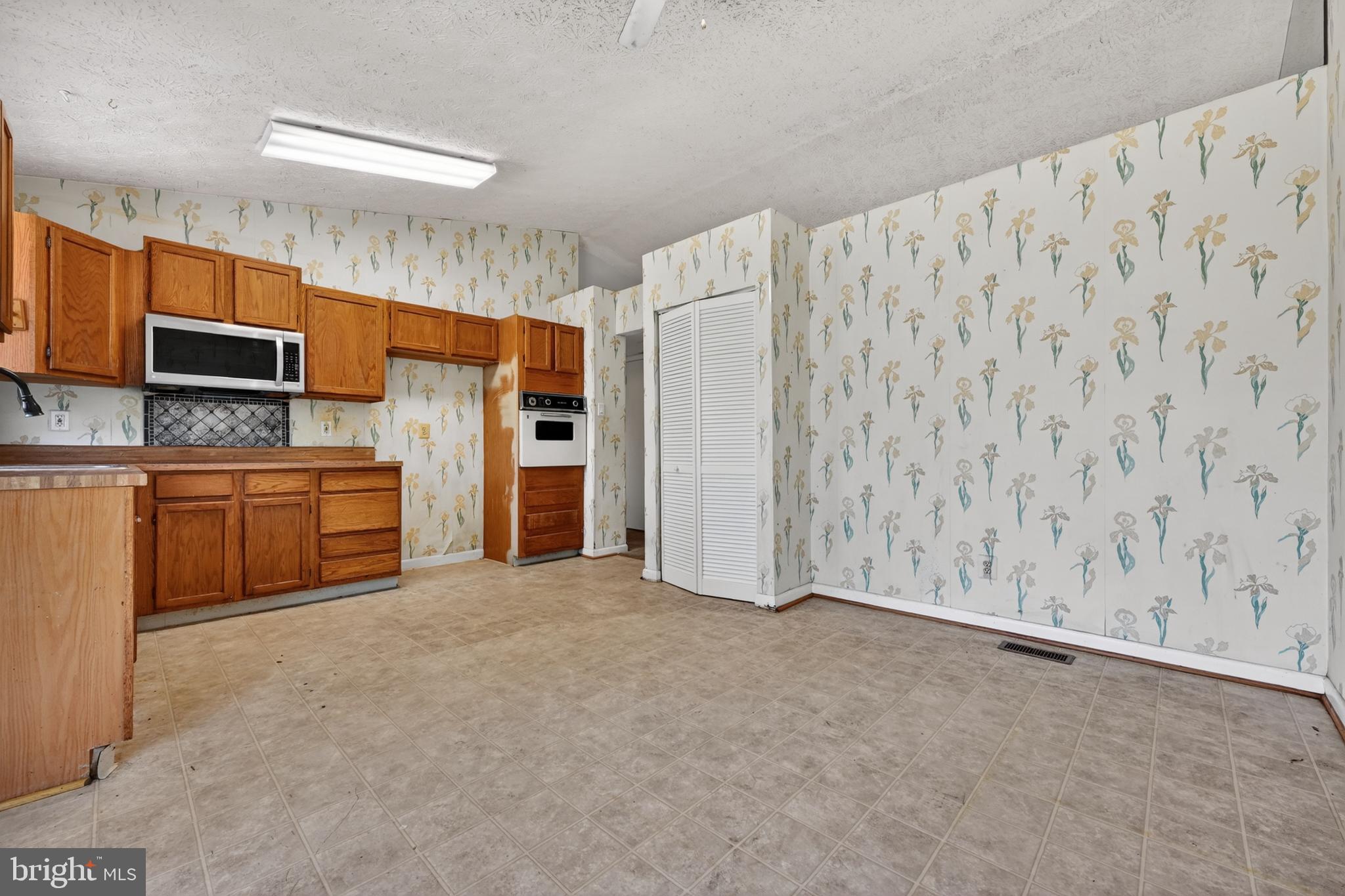 7838 Tick Neck Road Pasadena, MD 21122 - Photo 13 of 20 a view of kitchen with refrigerator cabinets and furniture