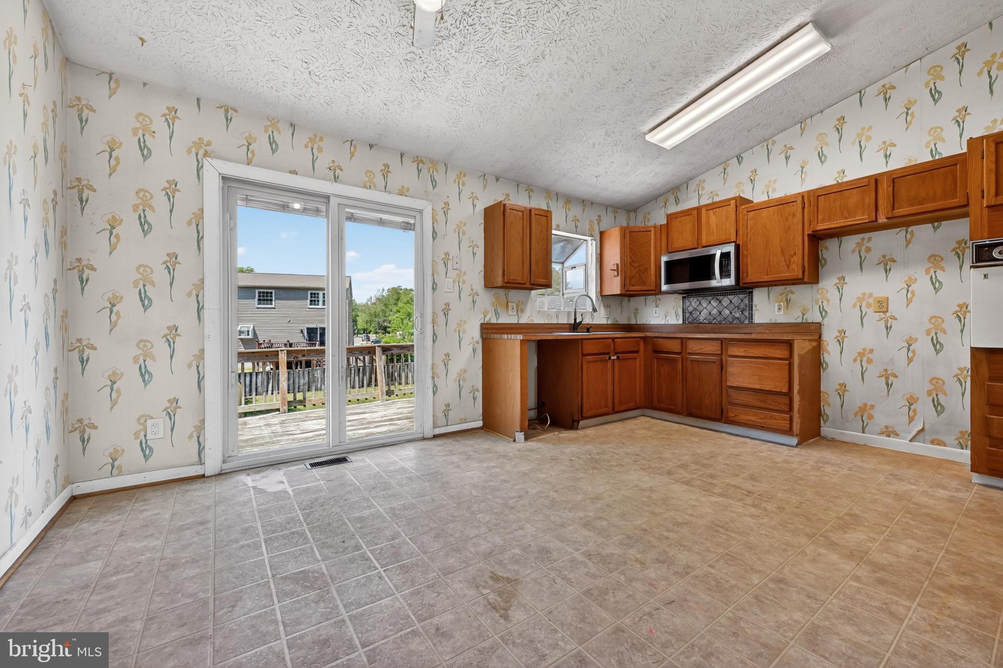 7838 Tick Neck Road Pasadena, MD 21122 - Photo 14 of 20 a large kitchen with stainless steel appliances granite countertop a refrigerator and a stove top oven