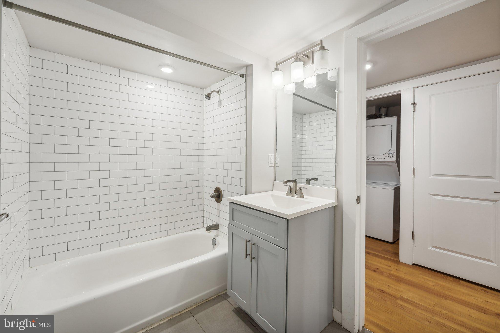 4300 Chestnut Street, Unit 1 Philadelphia, PA 19104 - Photo 14 of 30 a bathroom with a tub sink shower and two mirror