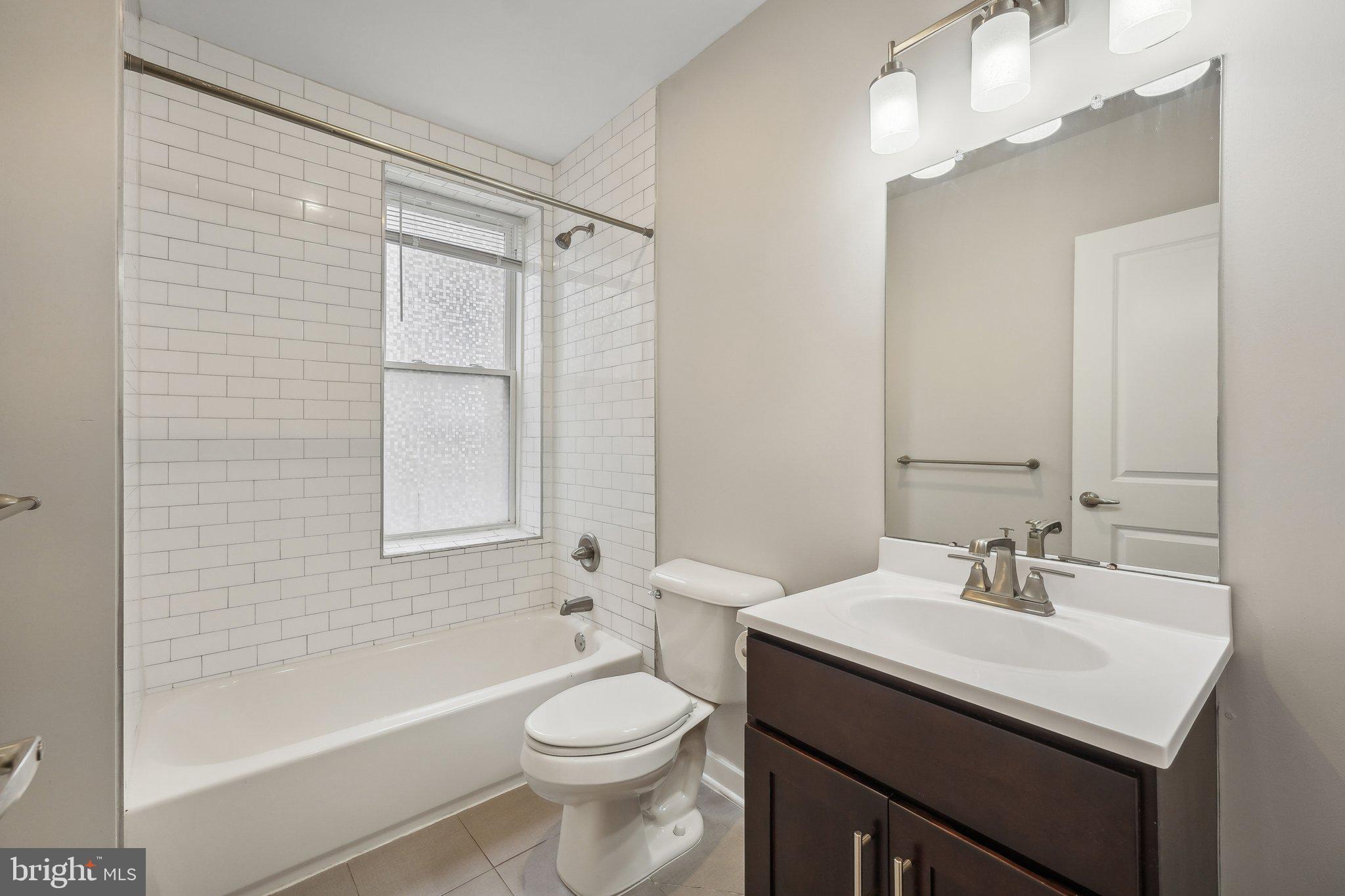4300 Chestnut Street, Unit 1 Philadelphia, PA 19104 - Photo 7 of 30 a bathroom with a sink a toilet and shower