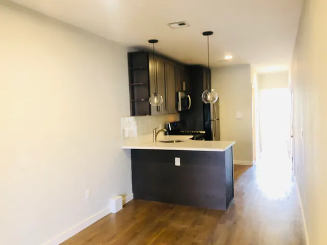 a view dining room with kitchen island stainless steel appliances wooden floor and view living room