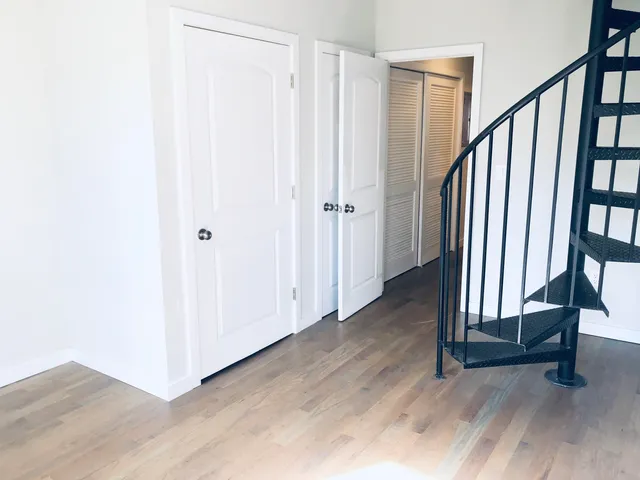 a view of a hallway with wooden floor and staircase