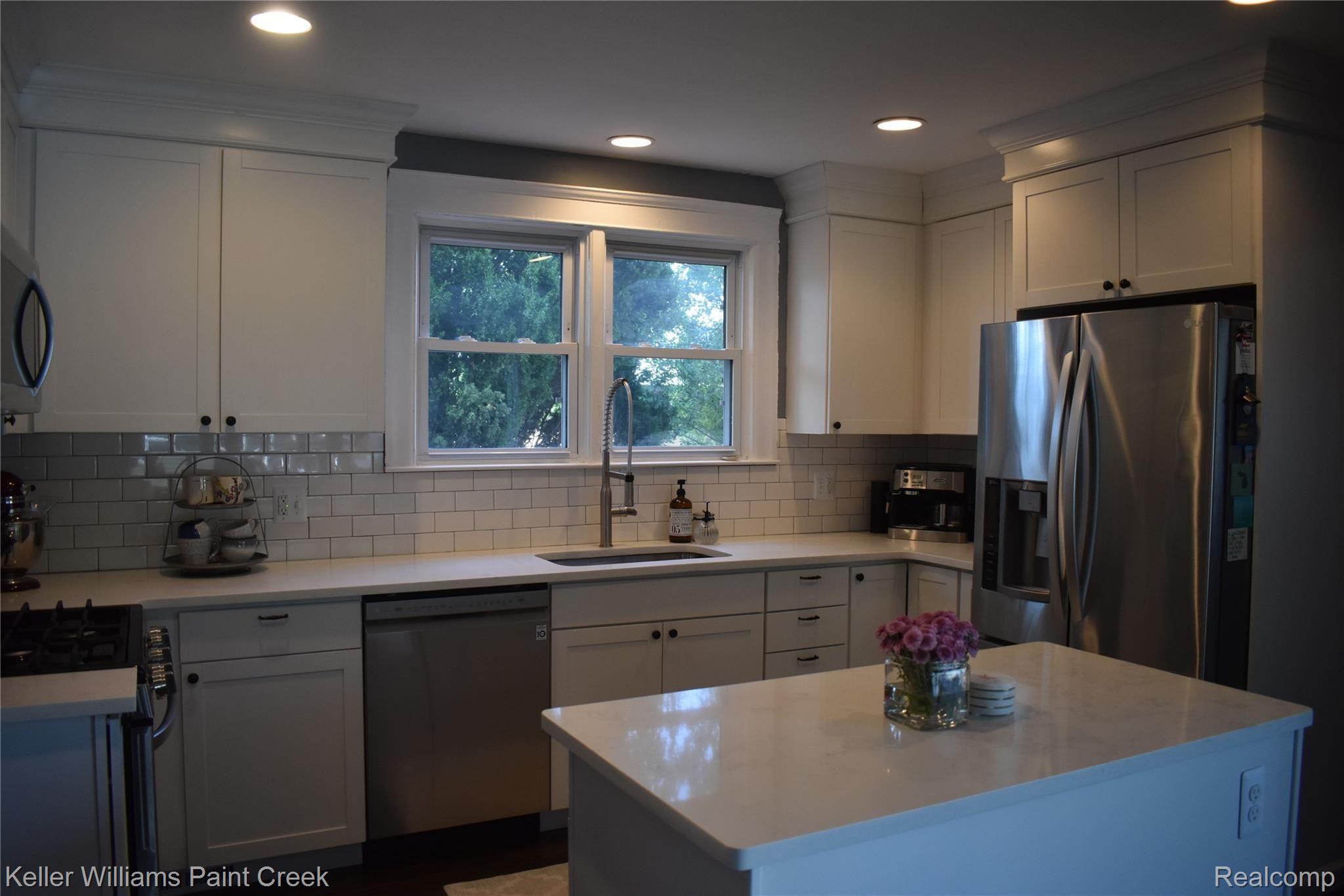 3116 Kenmore Road Berkley, MI 48072 - Photo 13 of 29 CHECKOUT THE WHITE TILE BACKSPLASH. THE ISLAND CONTAINS AN ELECTRICAL OUTLET & GARBAGE & RECYCLING BINS