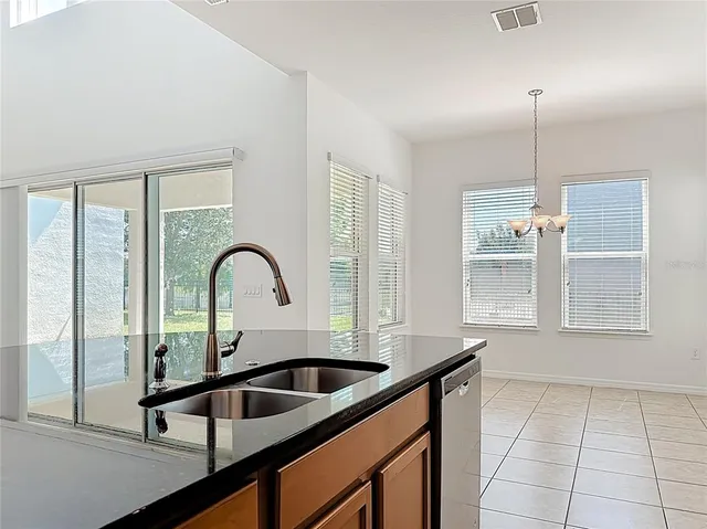 a kitchen with a sink a counter cabinets and a window