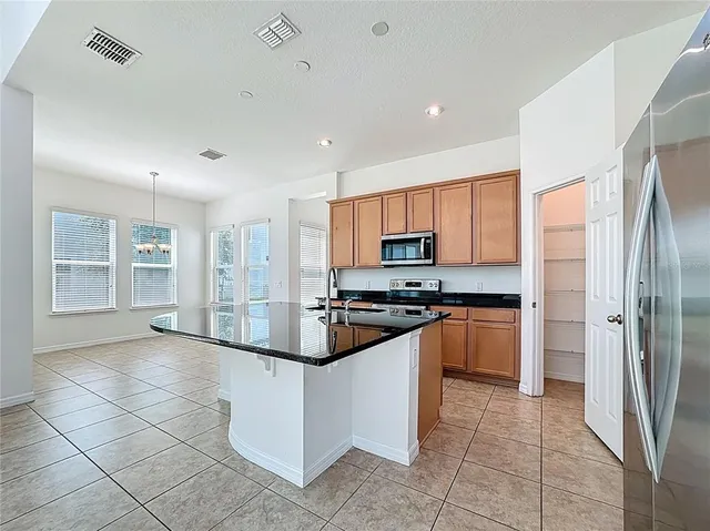 a kitchen with stainless steel appliances granite countertop a refrigerator and a stove top oven