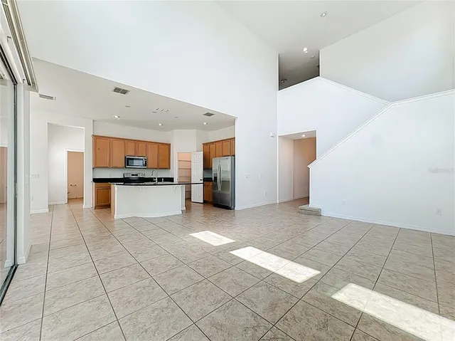 a view of kitchen with refrigerator and cabinets