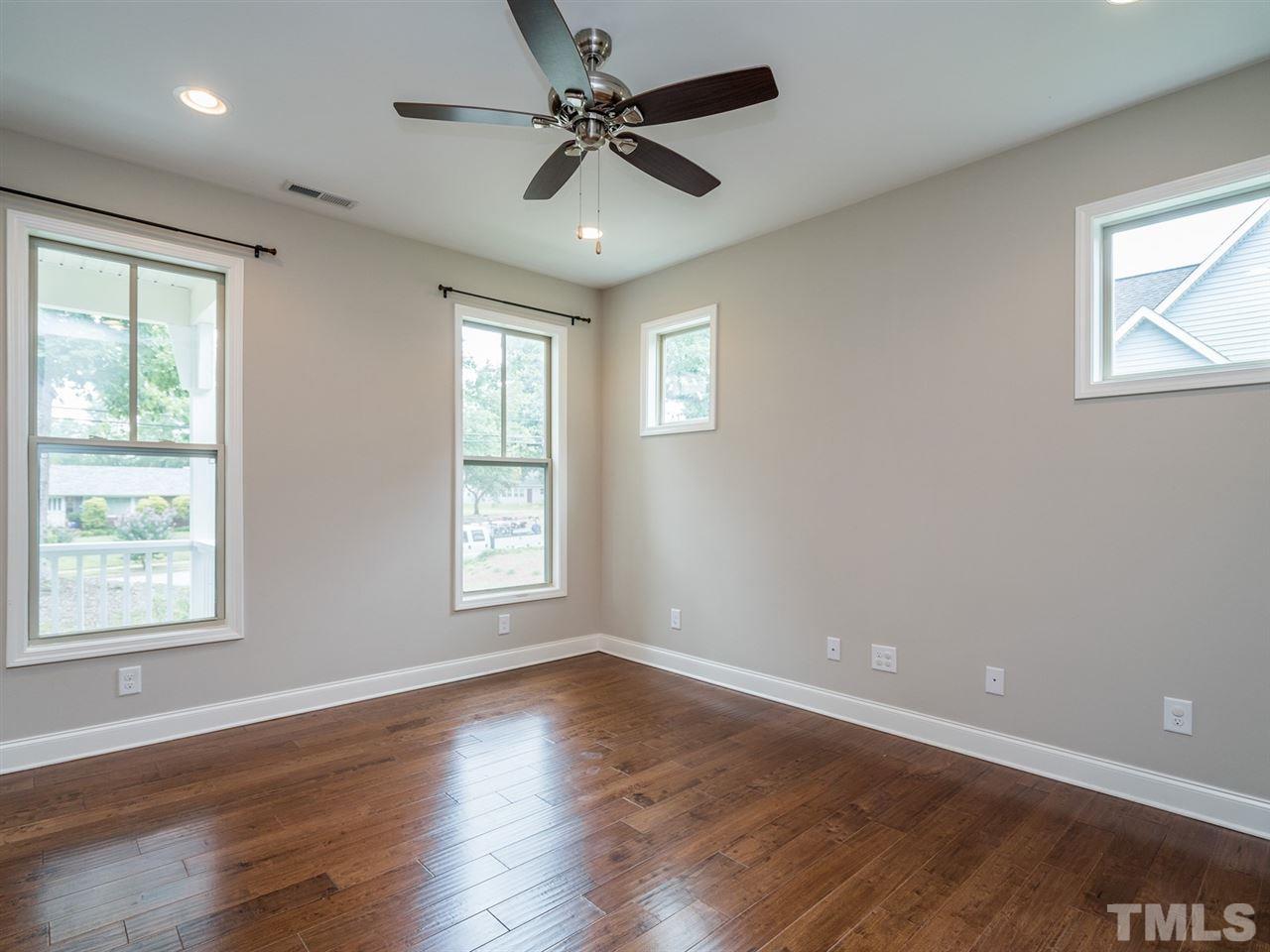 2308 Milburnie Road Raleigh, NC 27610 - Photo 3 of 25 a view of an empty room with wooden floor and a window