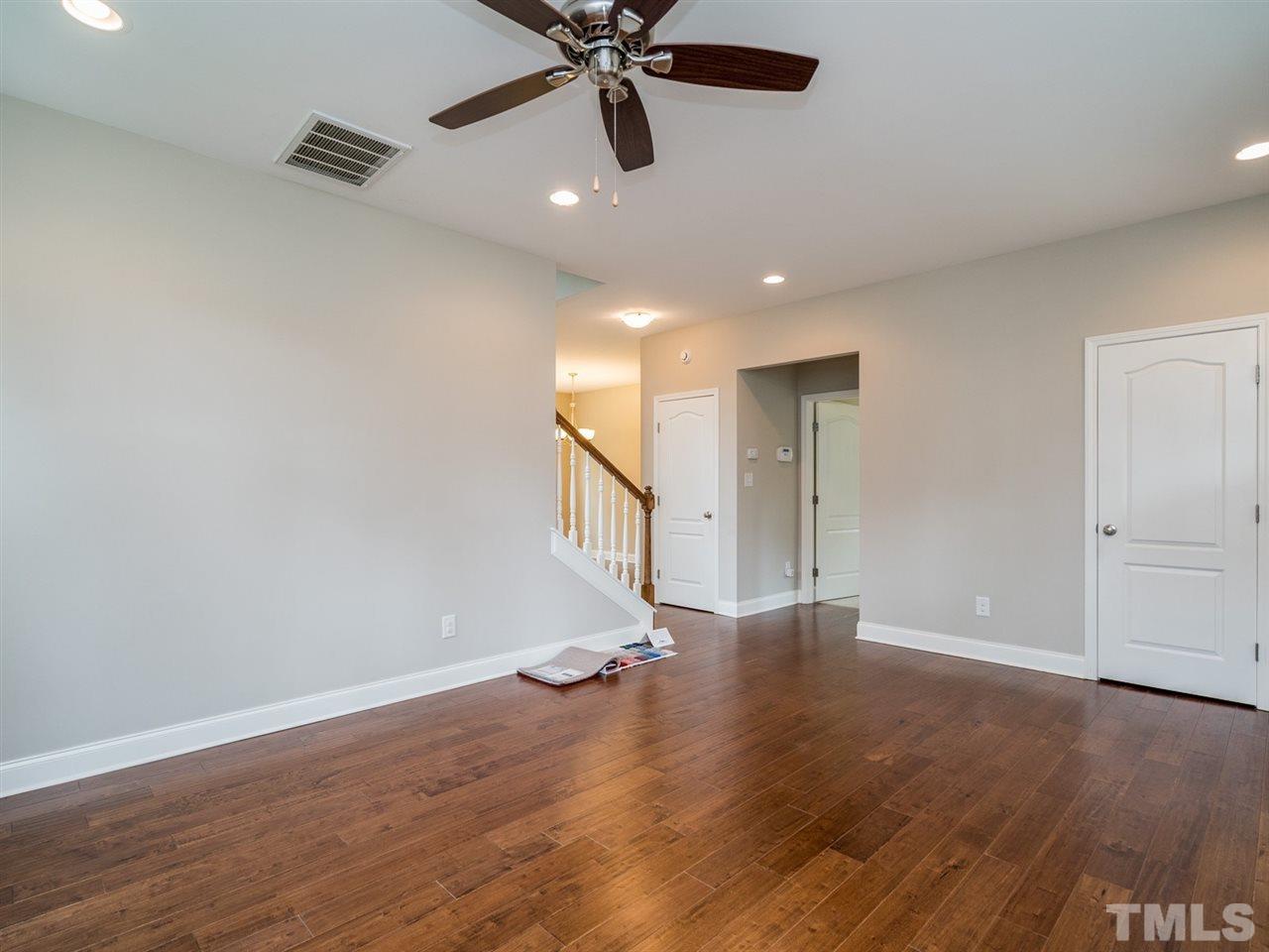 2308 Milburnie Road Raleigh, NC 27610 - Photo 5 of 25 a view of an empty room with wooden floor and a ceiling fan