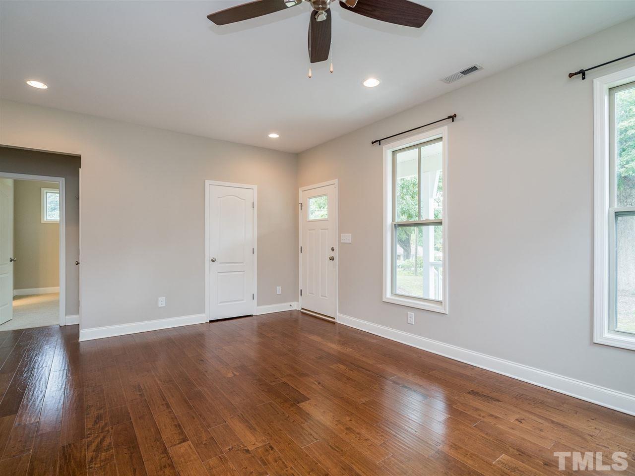 2308 Milburnie Road Raleigh, NC 27610 - Photo 6 of 25 a view of an empty room with wooden floor and a window