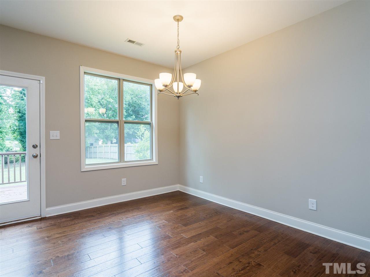 2308 Milburnie Road Raleigh, NC 27610 - Photo 7 of 25 an empty room with wooden floor and windows