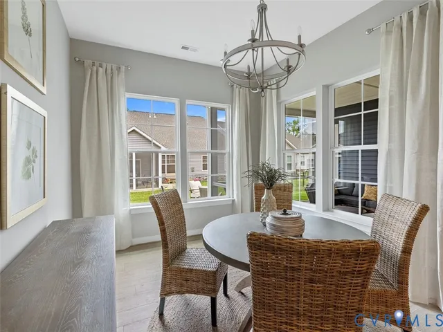 a dining room with furniture a chandelier and window