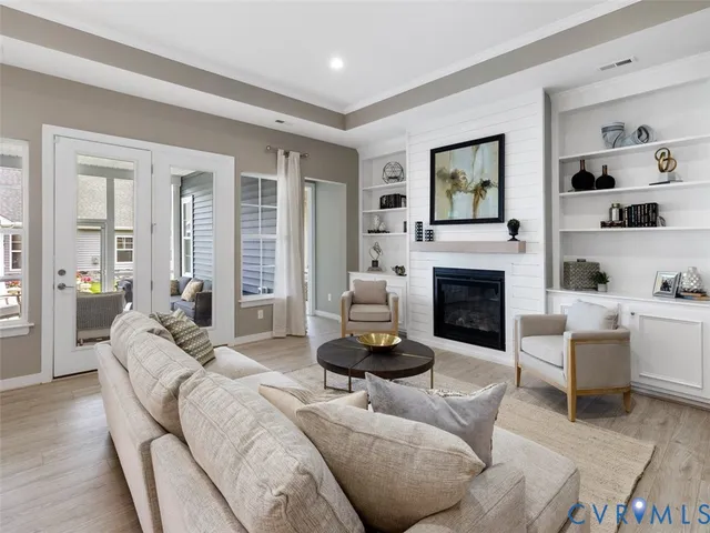 a living room with furniture a fireplace and a large window