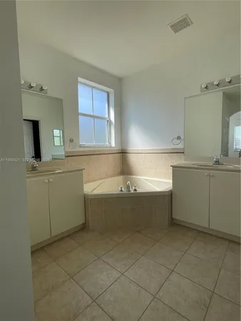 a bathroom with a bathtub sink and mirror