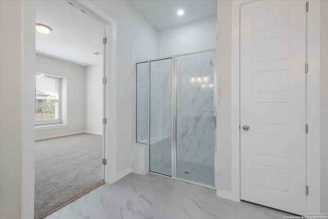 a bathroom with a shower and a glass door