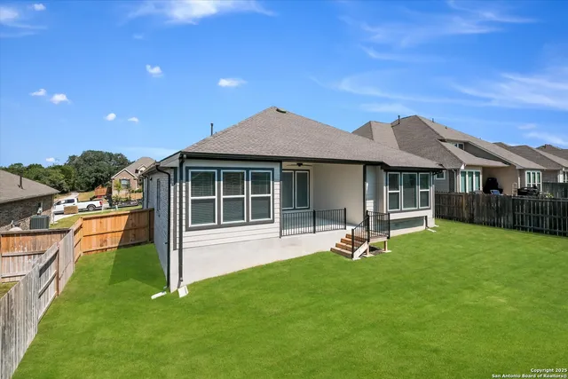 a patio with a table and chairs and potted plants