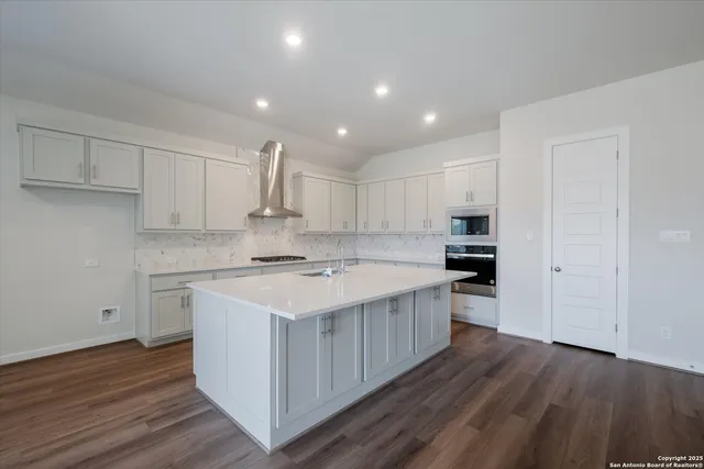 a kitchen with kitchen island a sink stainless steel appliances and cabinets