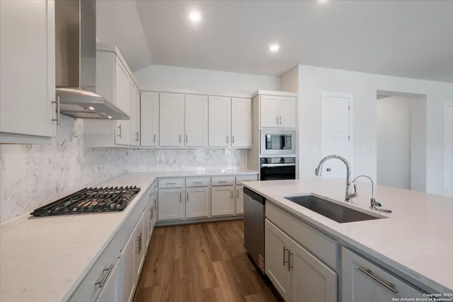 a kitchen with cabinets appliances a sink and a counter top space