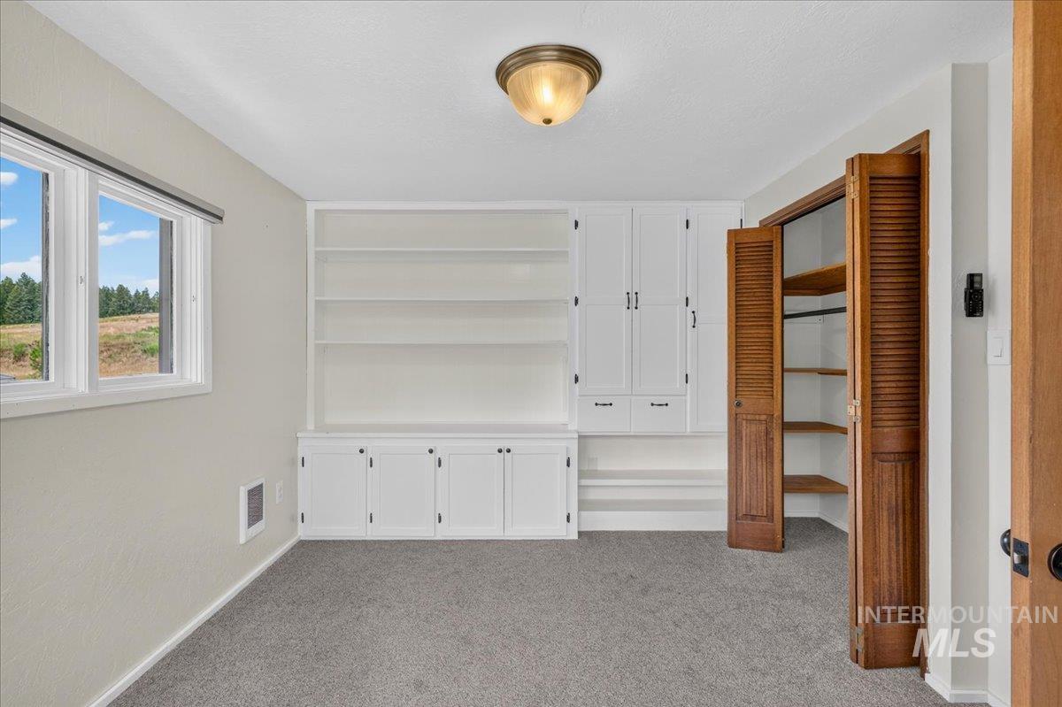1071 Reynolds Road Princeton, ID 83857 - Photo 36 of 43 Interior space featuring built-in white cabinetry, open shelving, and a window with outdoor scenery