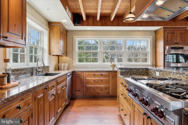 a kitchen with stainless steel appliances granite countertop a stove a sink and a granite counter tops