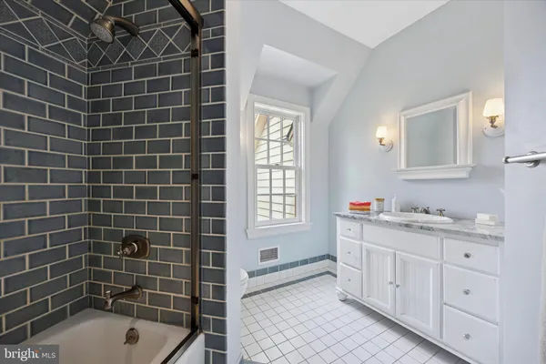 a bathroom with a tub a sink a window and a shower