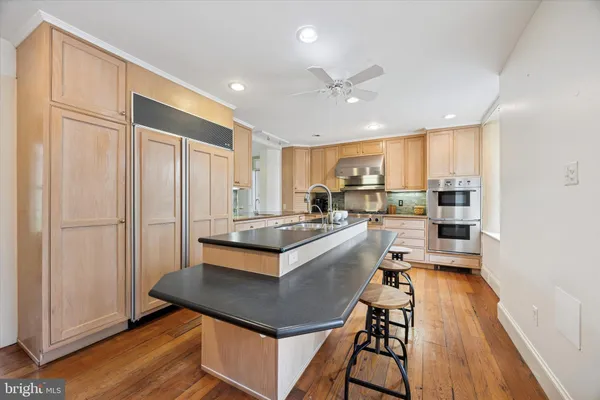 a kitchen with kitchen island stainless steel appliances a stove a sink a refrigerator and cabinets