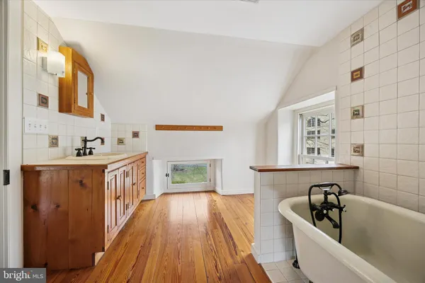 a bathroom with a bathtub sink and mirror