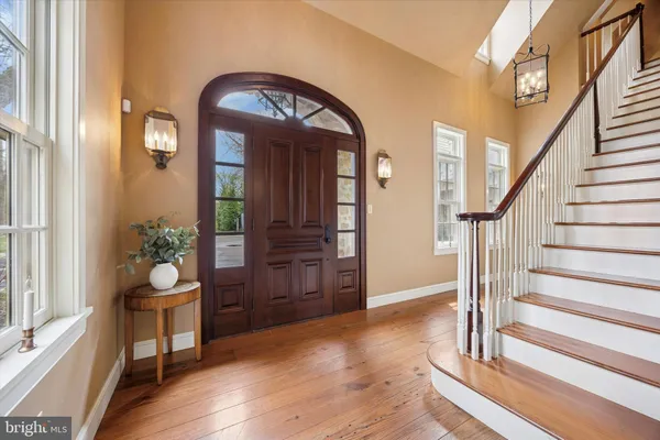 a view of a hallway with wooden floor windows and a kitchen view