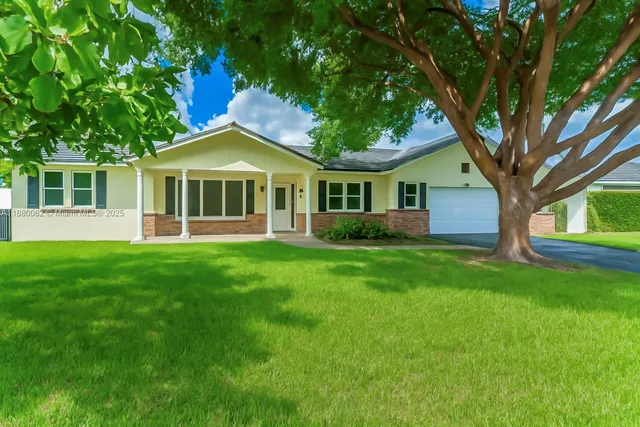 a front view of a house with a garden and yard