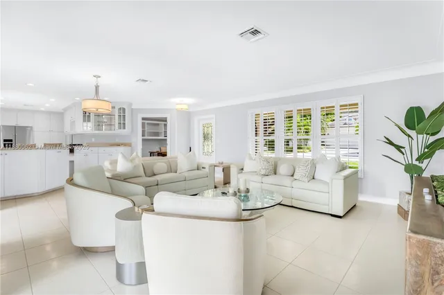 a large bed sitting in a bedroom next to a window and a chandelier