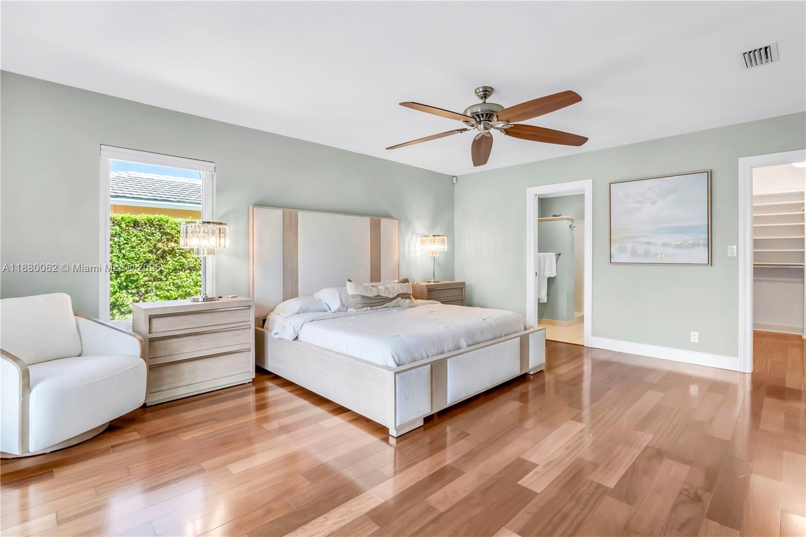 3921 Northeast 31st Avenue Lighthouse Point, FL 33064 - Photo 19 of 64 a spacious bedroom with a bed and a chandelier