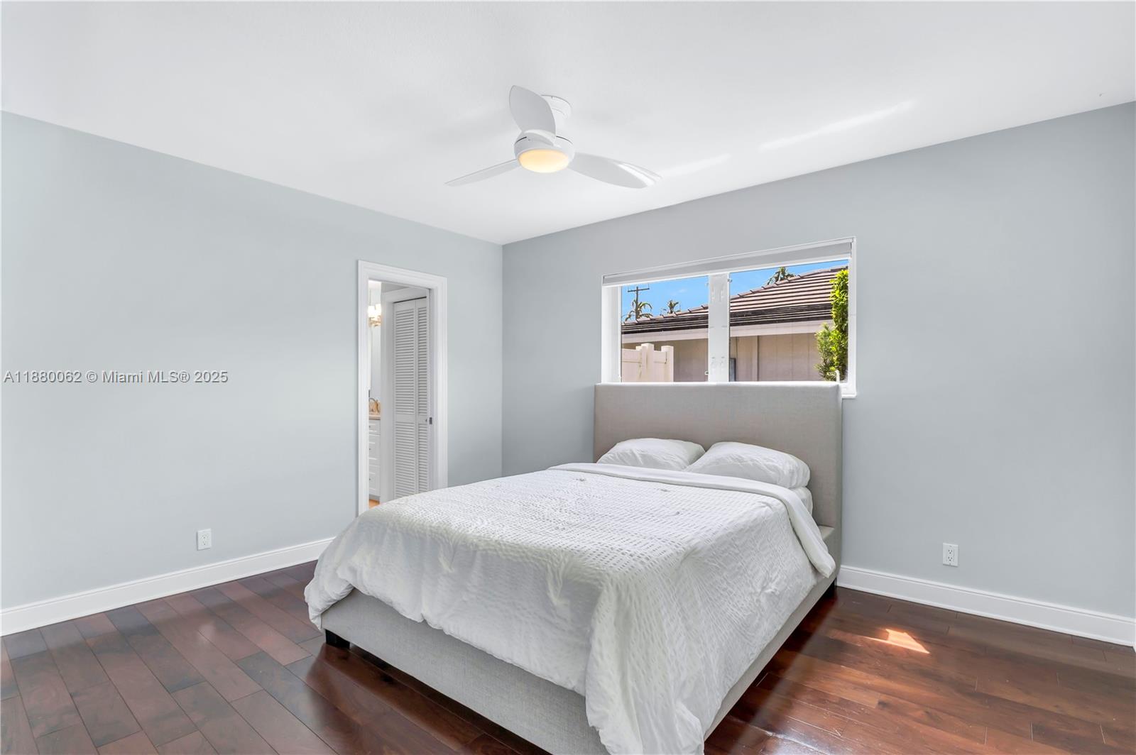 3921 Northeast 31st Avenue Lighthouse Point, FL 33064 - Photo 23 of 64 a large bed sitting in a bedroom next to a window and a chandelier