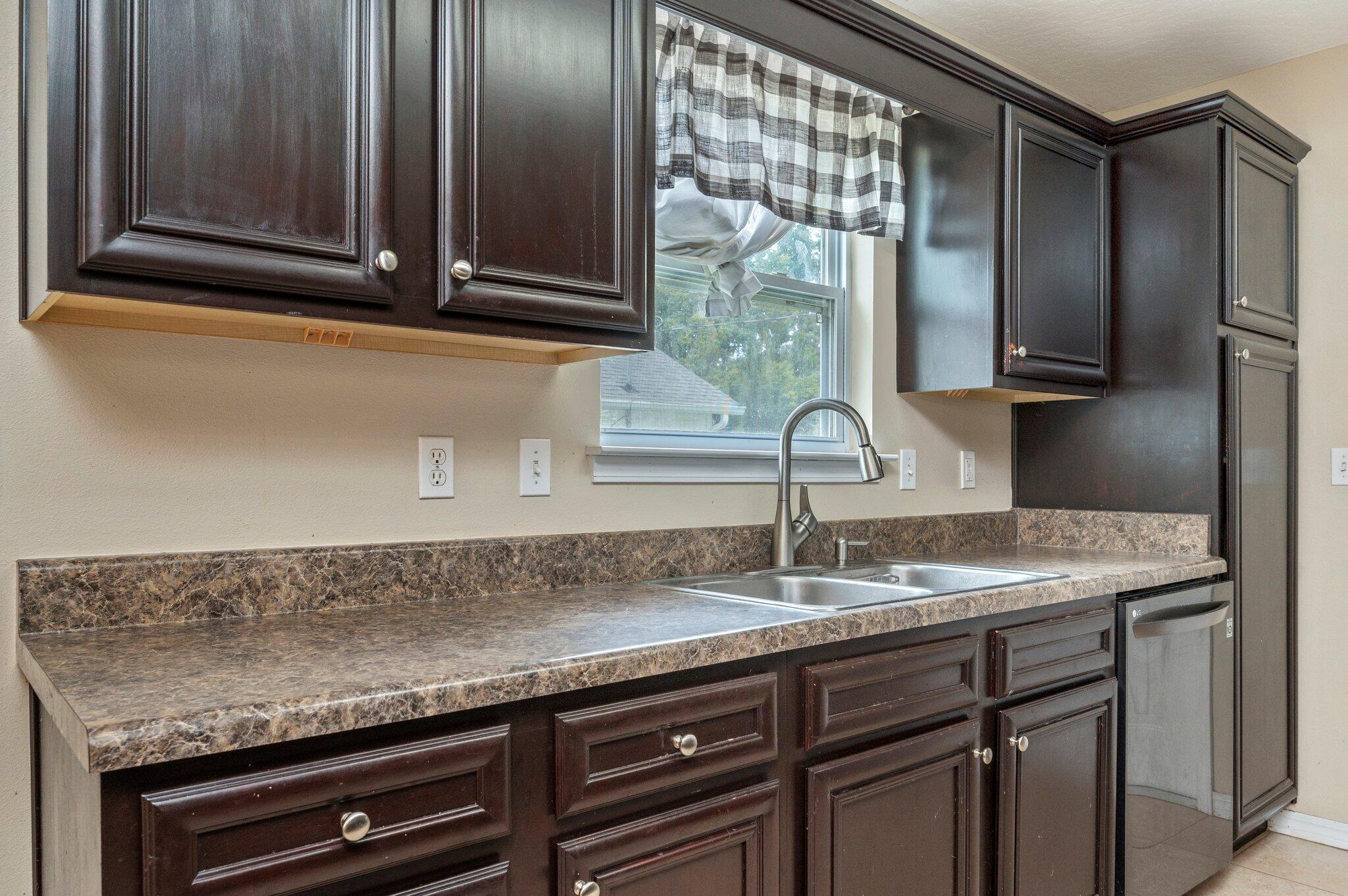 7 Snook Road Mary Esther, FL 32569 - Photo 19 of 38 a sink with granite countertop cabinets and window