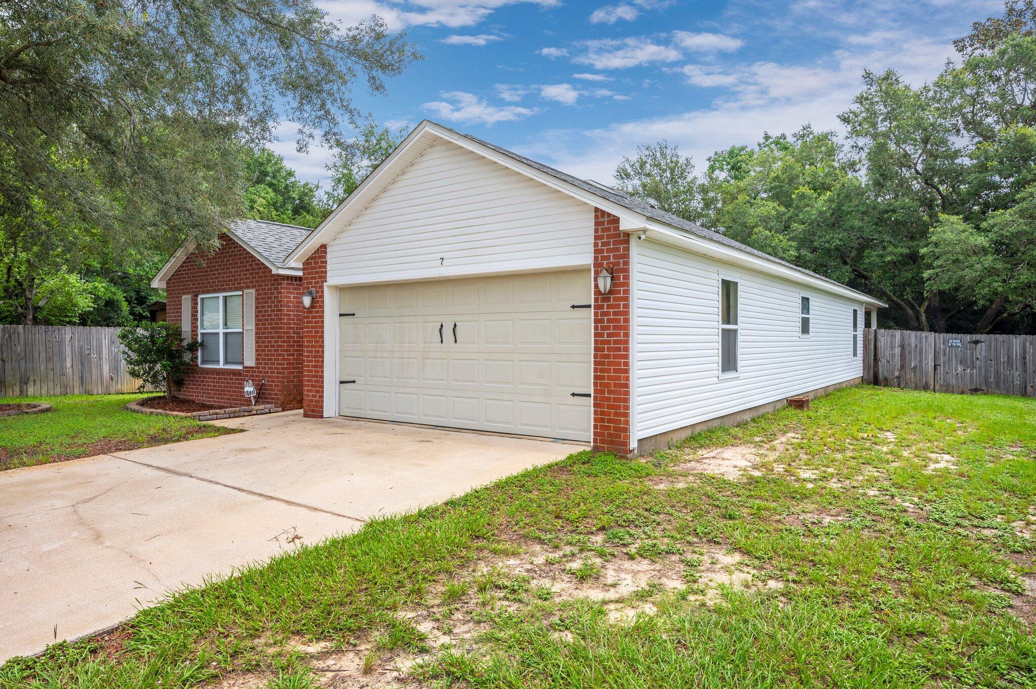 7 Snook Road Mary Esther, FL 32569 - Photo 2 of 38 a view of a backyard with a garden and garage