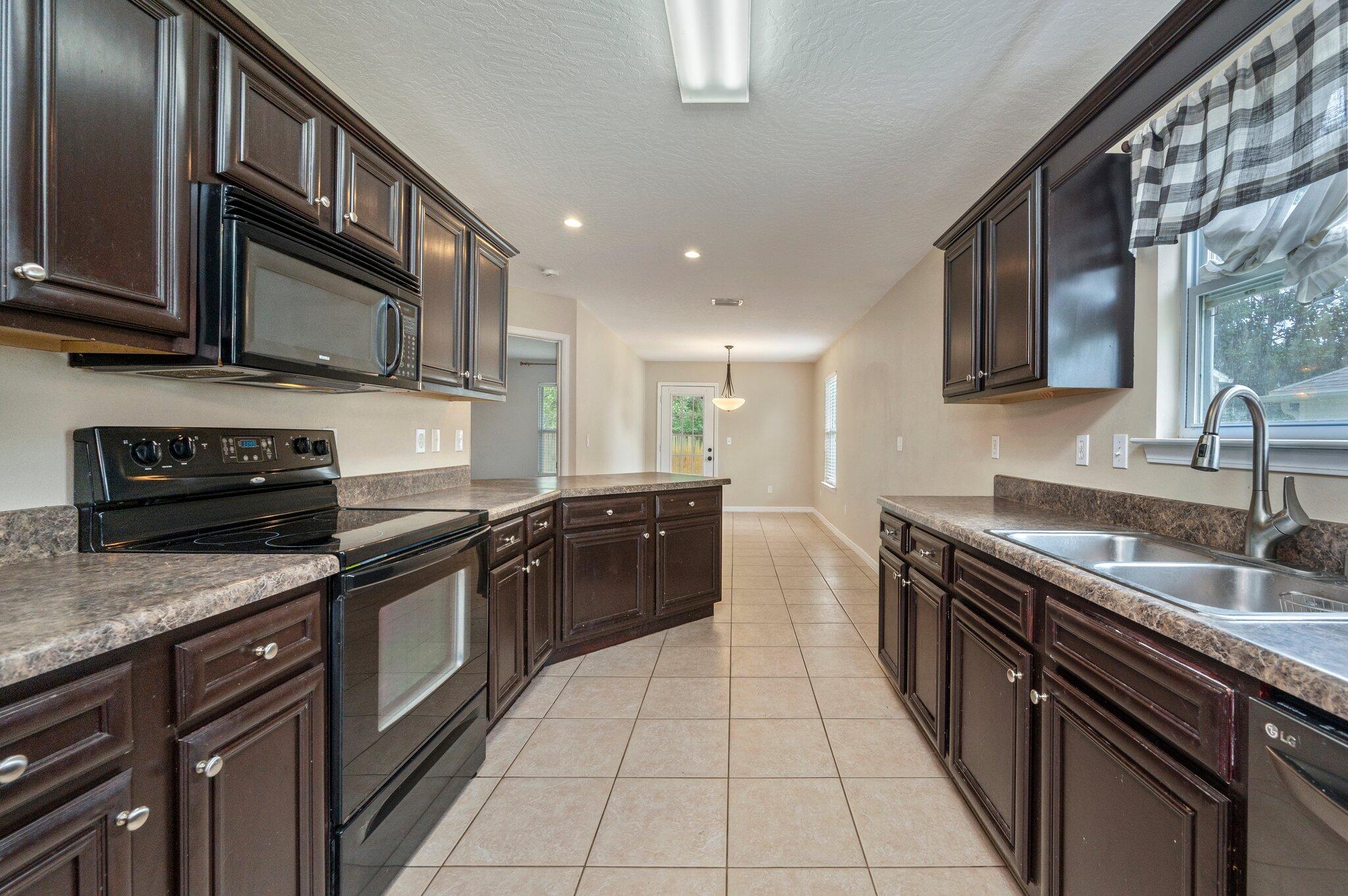 7 Snook Road Mary Esther, FL 32569 - Photo 21 of 38 a kitchen with stainless steel appliances granite countertop a stove a sink and a microwave