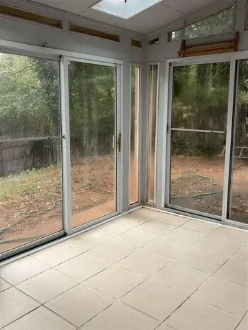 a view of backyard with large window and wooden floor
