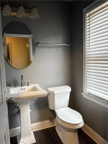 a bathroom with a toilet sink and mirror