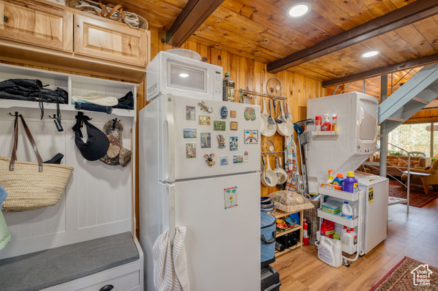 714 Spotted Fawn Way Kamas, UT 84036 - Photo 11 of 34 Kitchen featuring white appliances, wooden walls, light wood-style flooring, estacked washer and dryer, and a wooden ceiling with exposed beams