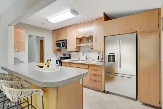 a kitchen with stainless steel appliances a refrigerator stove microwave and sink